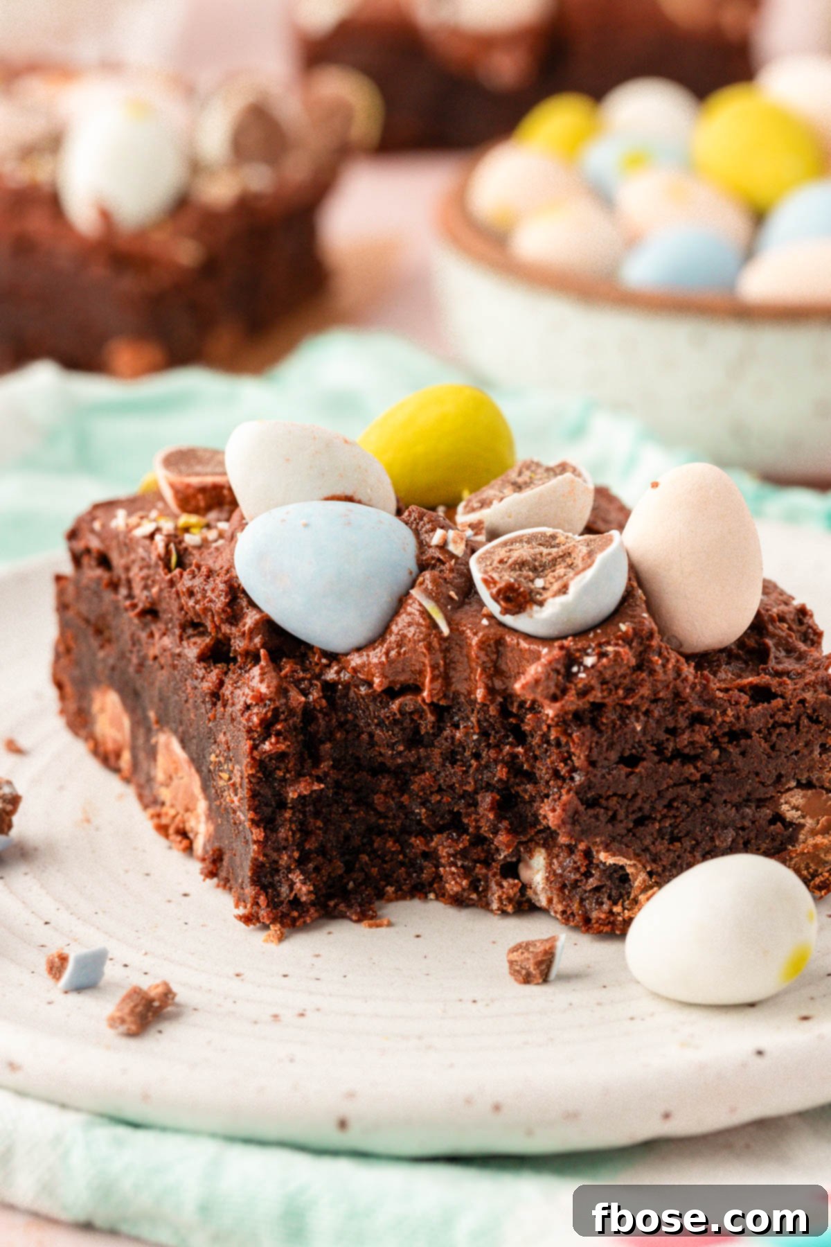 Molten Cadbury Egg Brownies 8 A single Cadbury Brownie on a small white plate, with a bite playfully taken out.