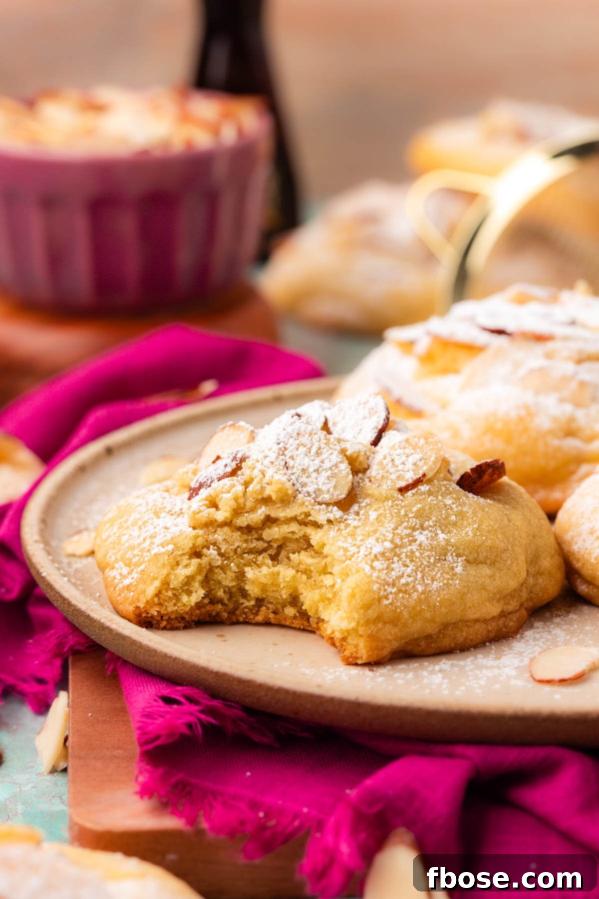 Flaky Almond Cookie Delights 6 Almond Croissant cookies on a plate with one missing a bite.