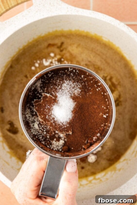 Coffee Brownies 12 Dry ingredients being sifted into wet ingredients in a bowl to make brownies.