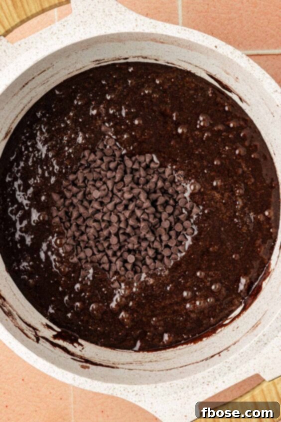 Coffee Brownies 13 Mini chocolate chips being added to a saucepan to make brownie batter.