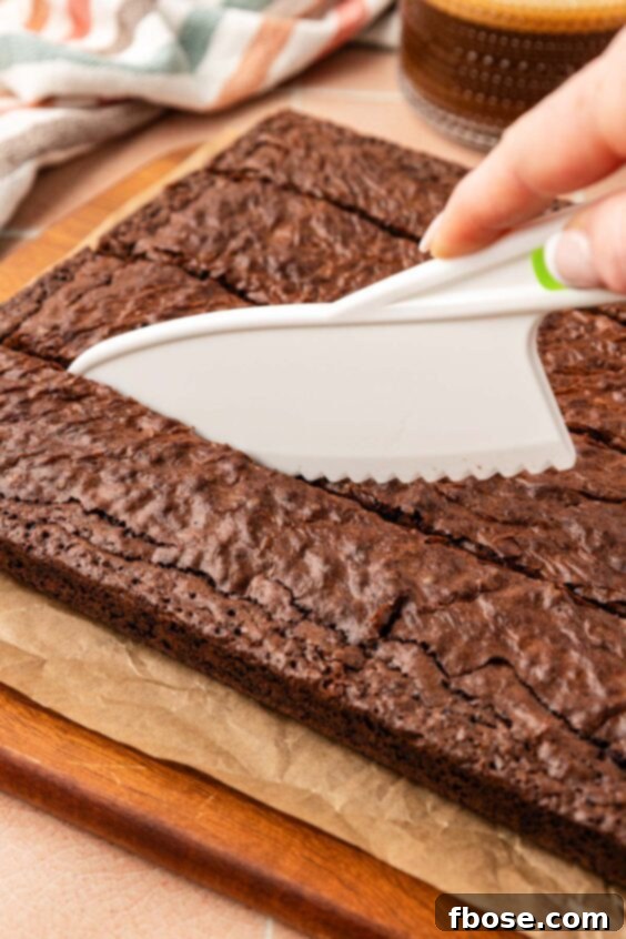 Coffee Brownies 15 A plastic knife cutting brownies on a cutting board.