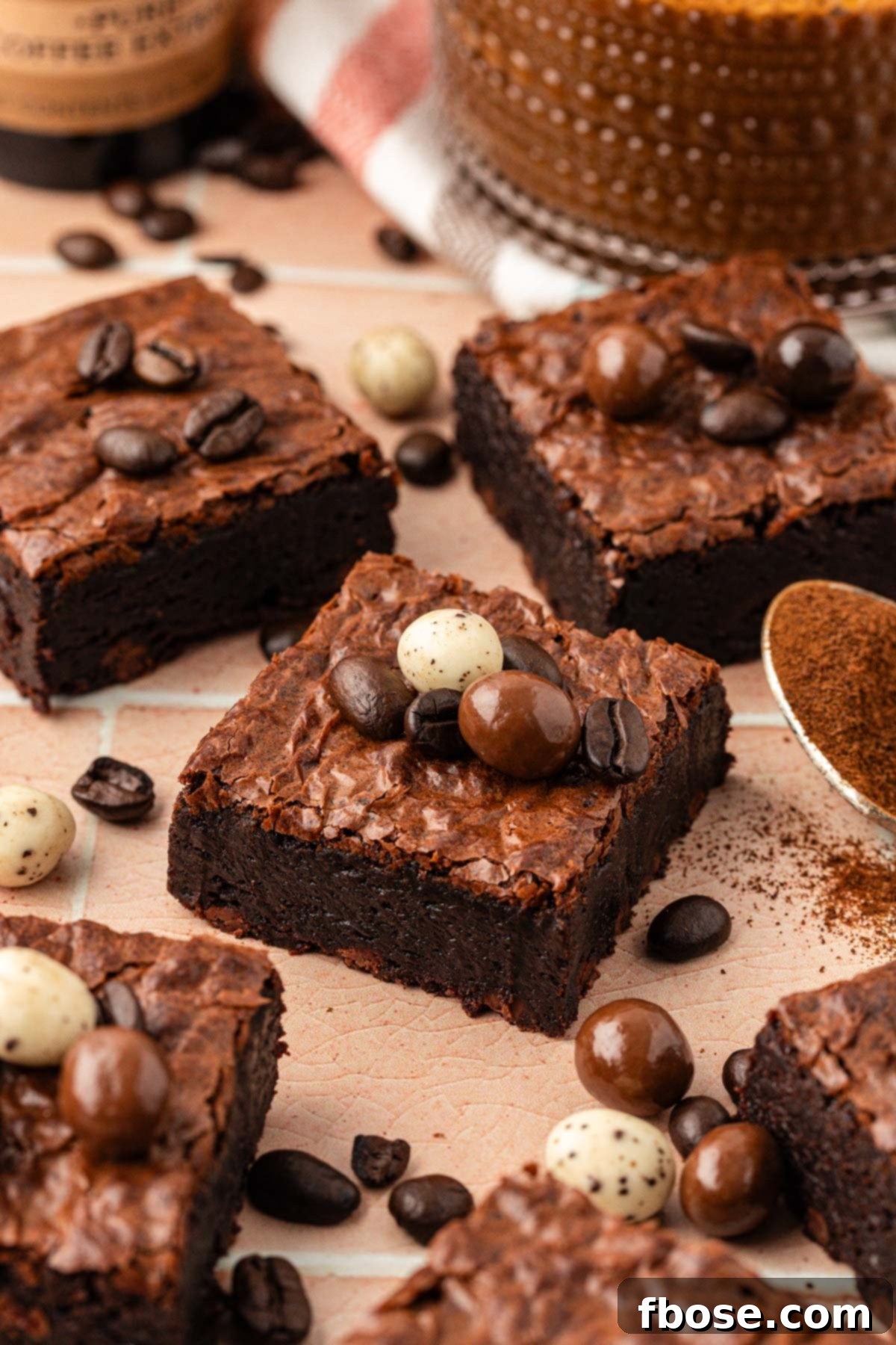 Coffee Brownies 5 Espresso brownie slices on a table with chocolate covered espresso beans on them.