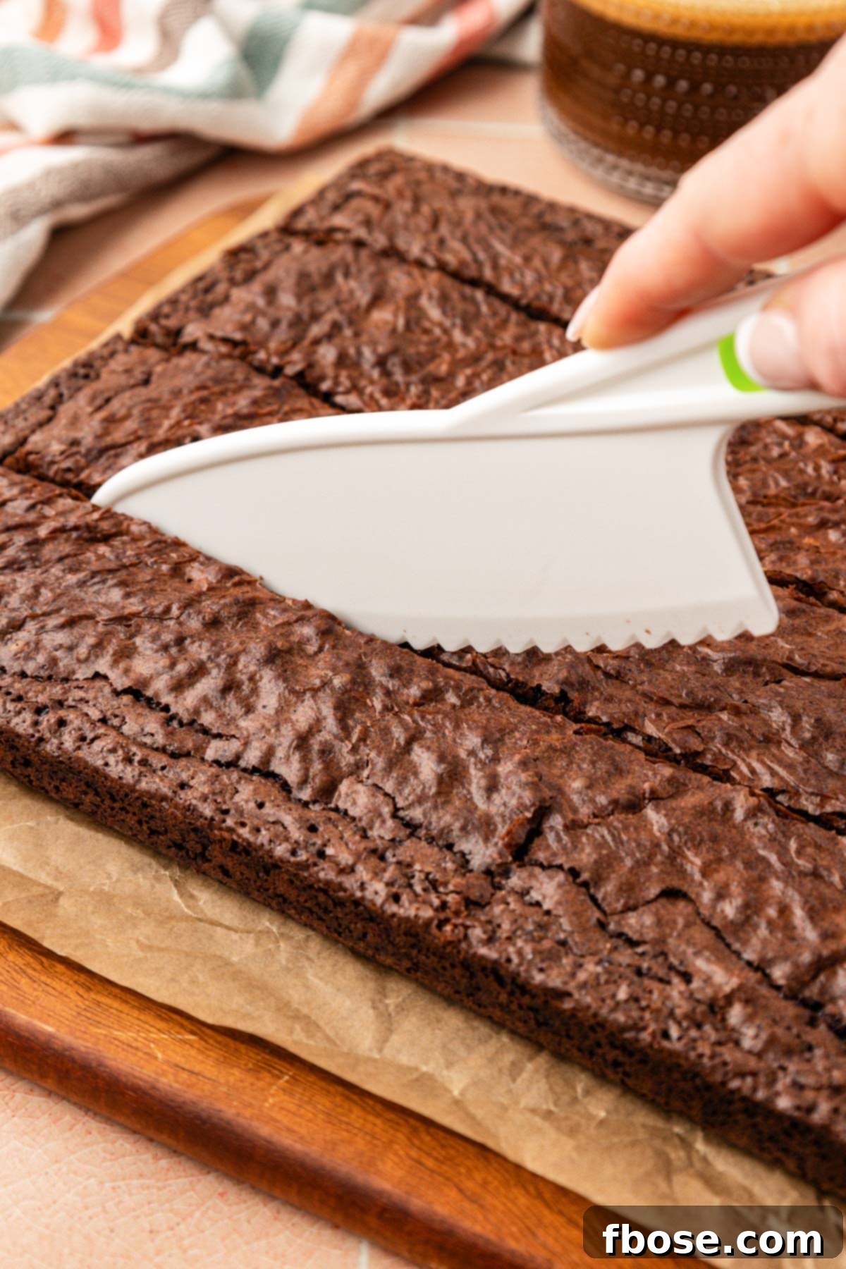 Coffee Brownies 6 A plastic knife cutting brownies on a cutting board.