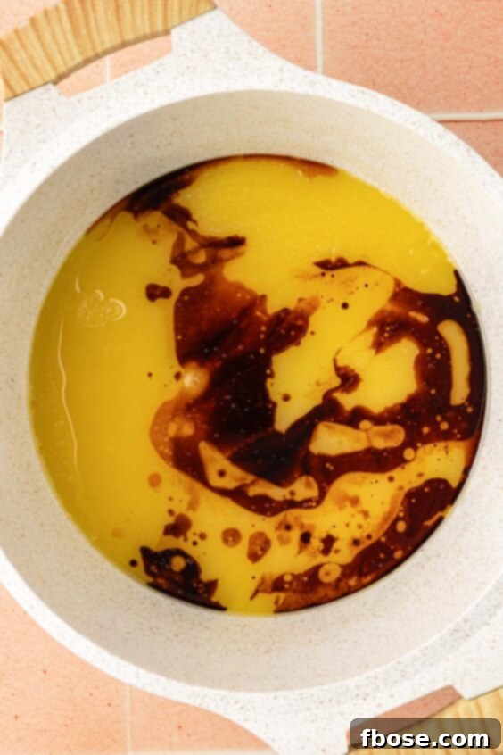Coffee Brownies 10 Vanilla and coffee extract being added to melted butter and sugar in a saucepan