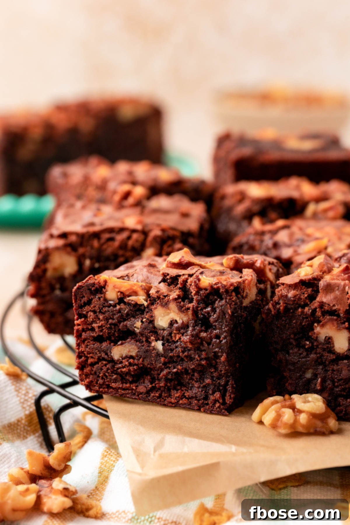 Close up of a brownie with walnuts on a piece of parchment paper.