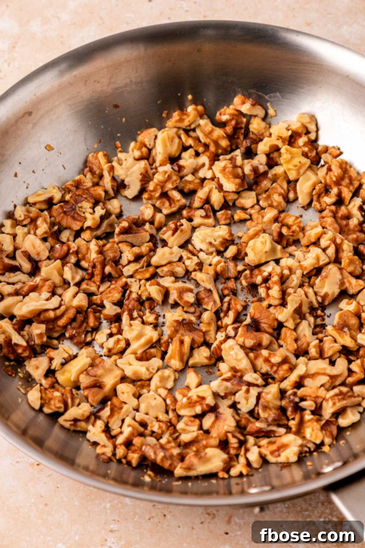 Walnuts being toasted in a skillet.