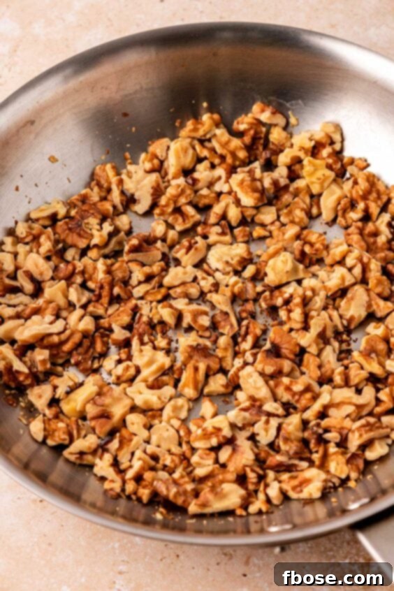 Walnuts being toasted in a skillet.