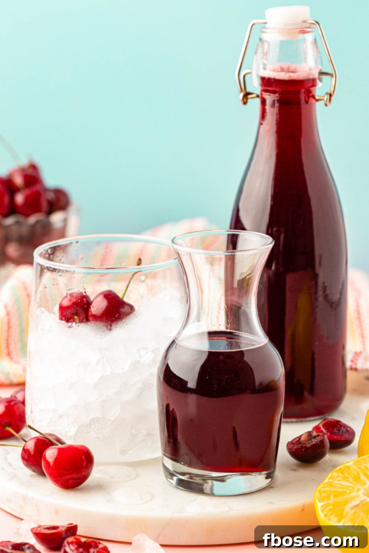 A glass bottle of homemade cherry simple syrup, perfectly clear and deep red, standing proudly next to a simple glass, inviting a refreshing drink.