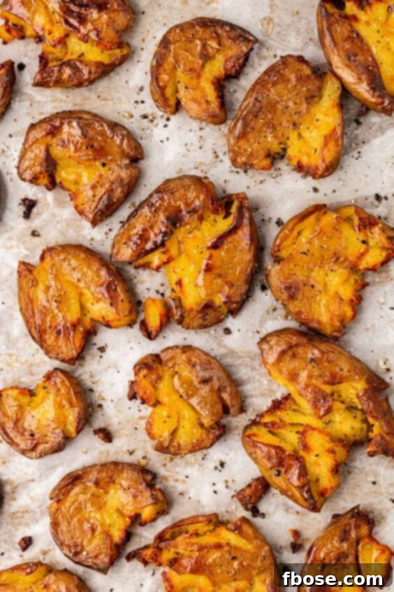 Roasted smashed potatoes on a baking pan.