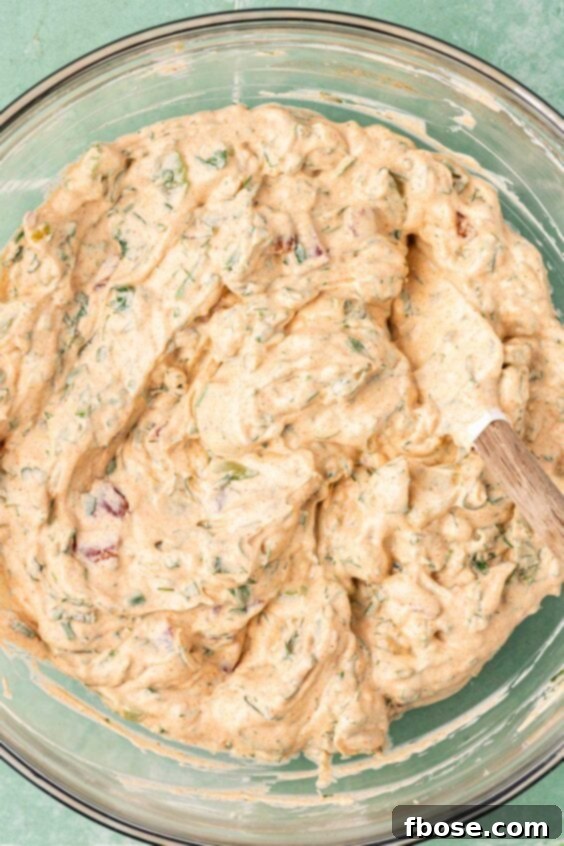 Dressing for smashed potato salad prepared in a glass bowl.