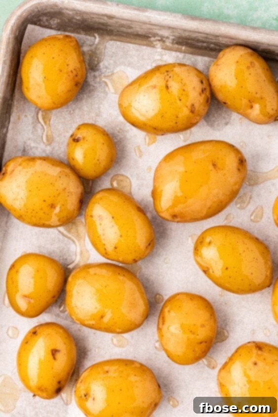Baby potatoes and oil on a baking pan.