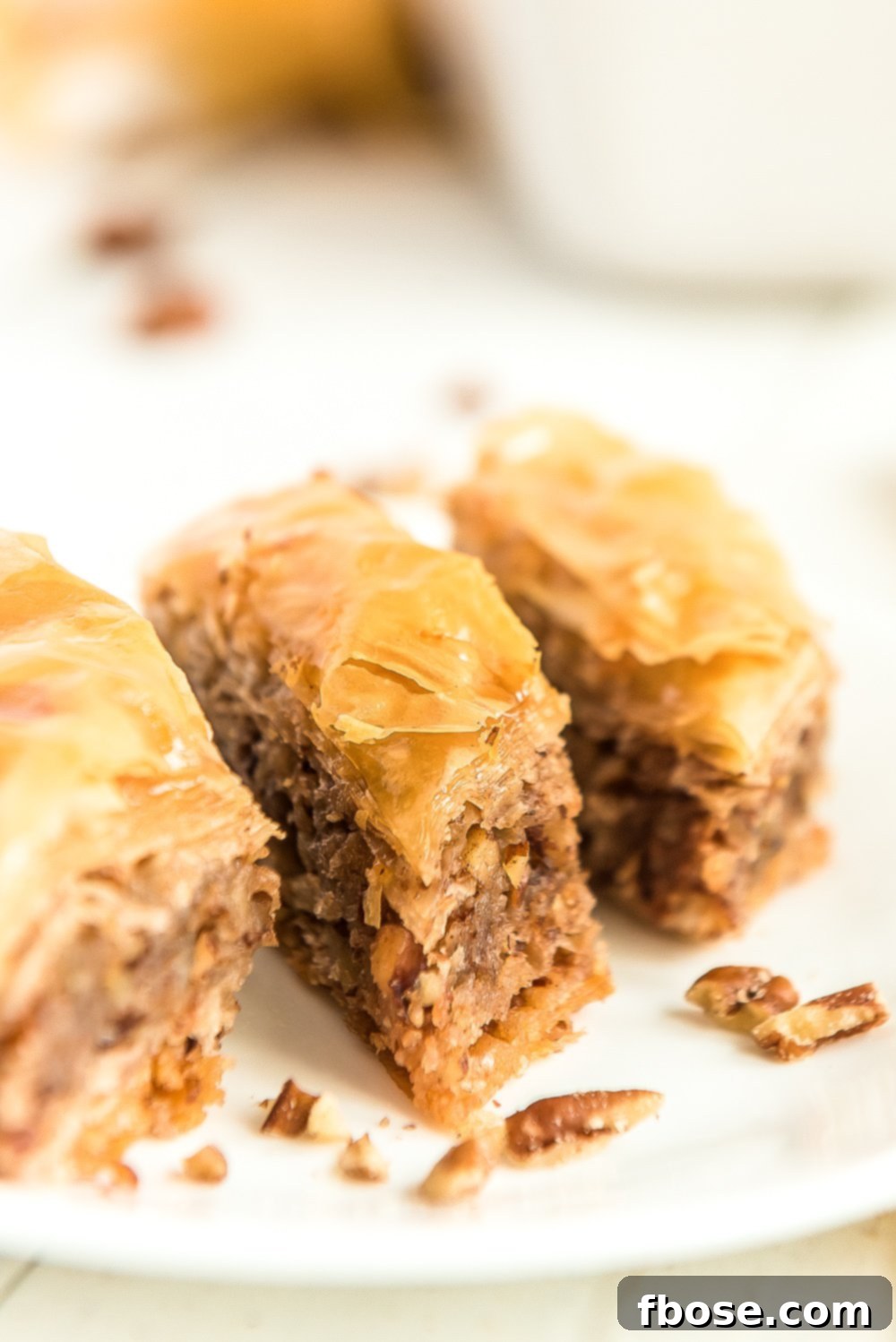 Effortless Homemade Baklava 3 Three pieces of baklava on a white plate.