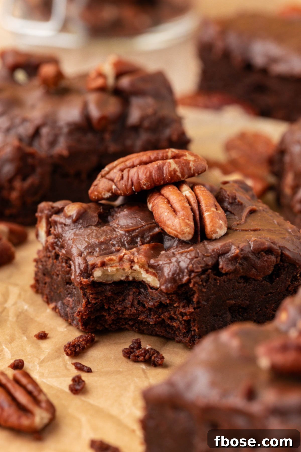 Close up of Texas Sheet Cake Brownies on a piece of parchment paper, highlighting their fudgy texture and rich icing.