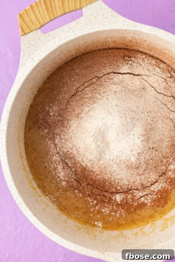 Flour and cocoa powder sifted into a pot to make brownies.