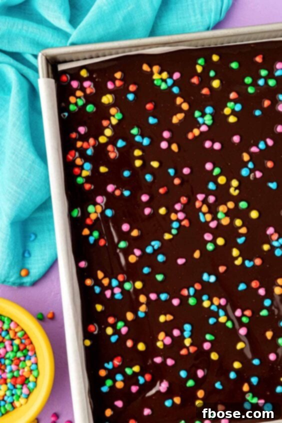 Candy coated chocolate sprinkles on a batch of frosted brownies.
