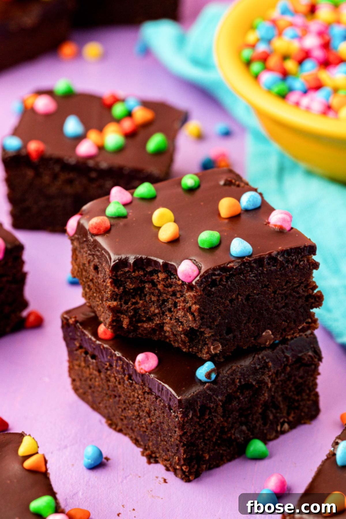 Close up of two cosmic brownies stacked with the top one missing a bite, showing the fudgy texture.