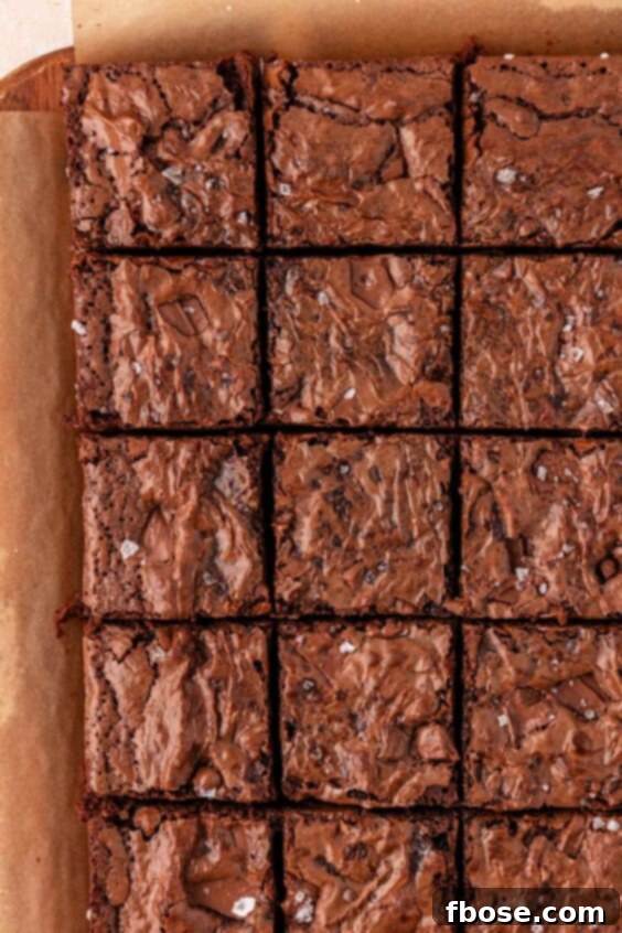 Sliced chocolate chunk brownies on a piece of parchment paper.