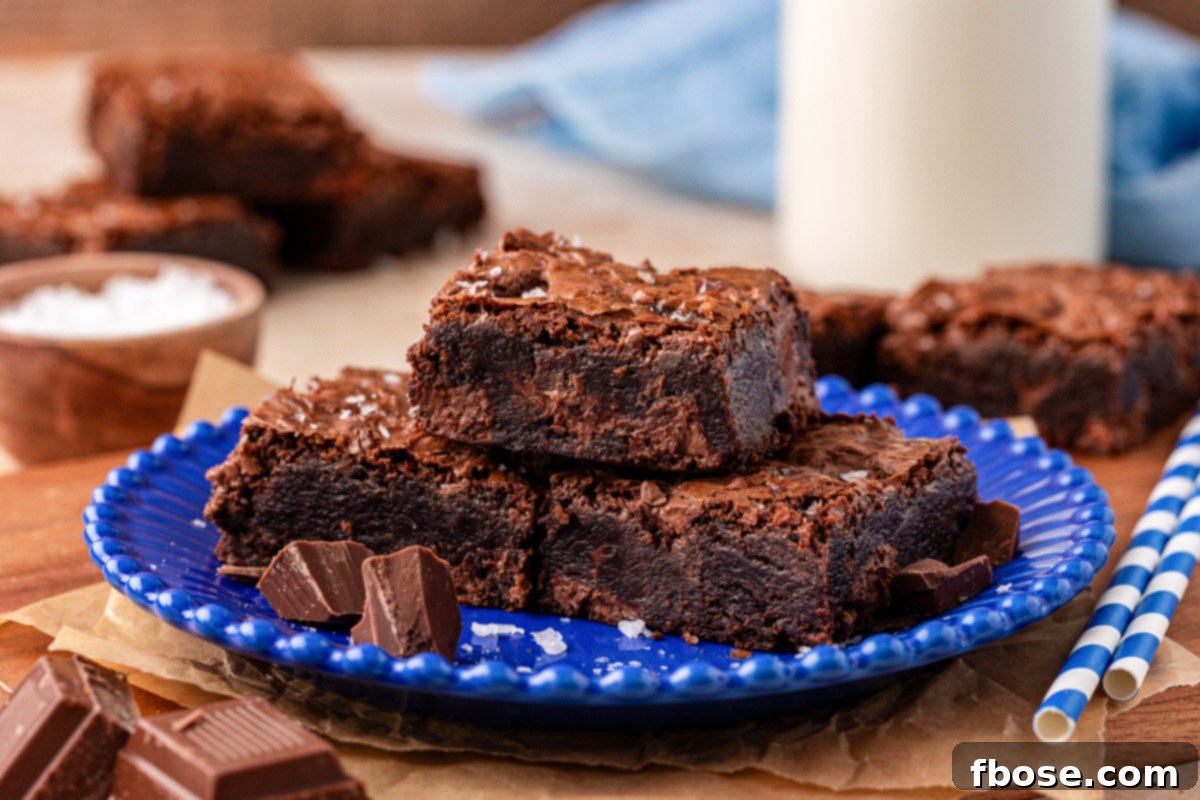 Three chocolate chunk brownies on a plate.