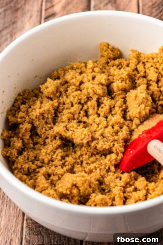Graham cracker crumb crust being mixed in a bowl.