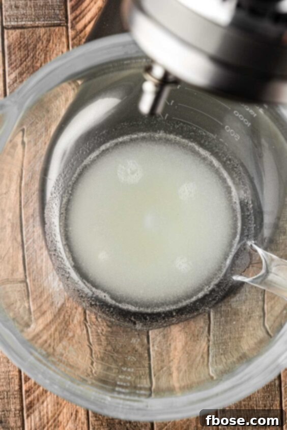 Gelatin and water in a glass stand mixer bowl.