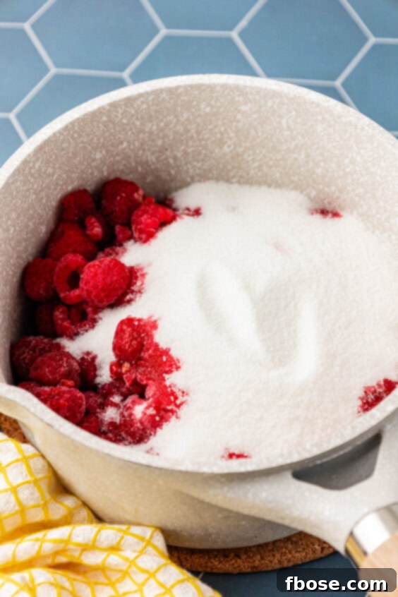 Raspberries and sugar in a small pot.