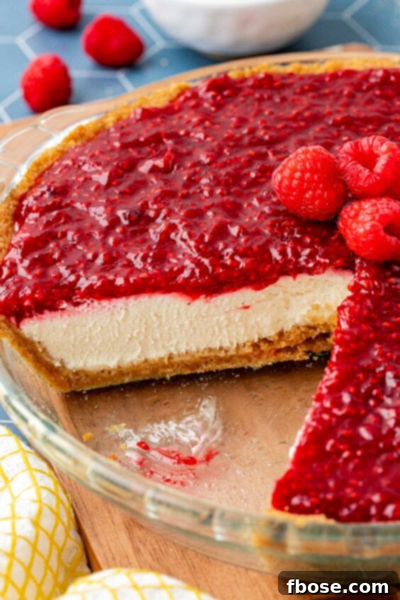 Close up of a raspberry cream pie with slices missing from the dish.