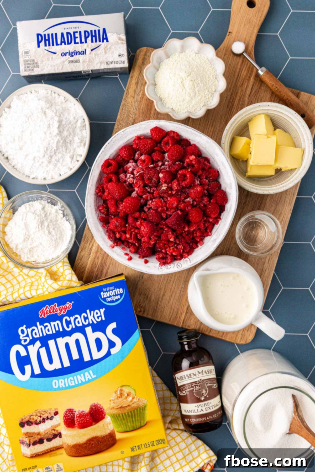 Overhead photo of fresh and frozen ingredients laid out on a wooden table, ready to make raspberry cream pie.