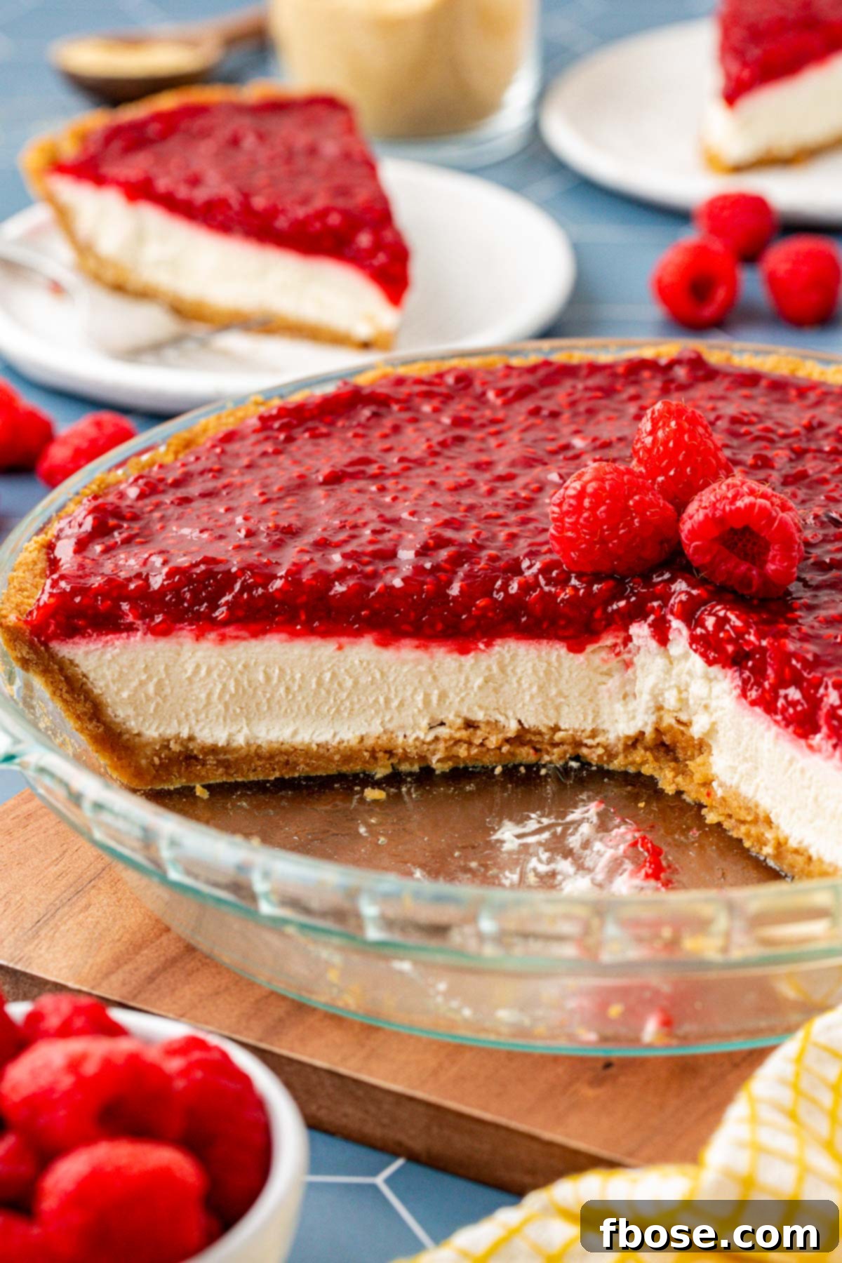 Close up of a no-bake raspberry cream pie with several slices already removed from the dish.