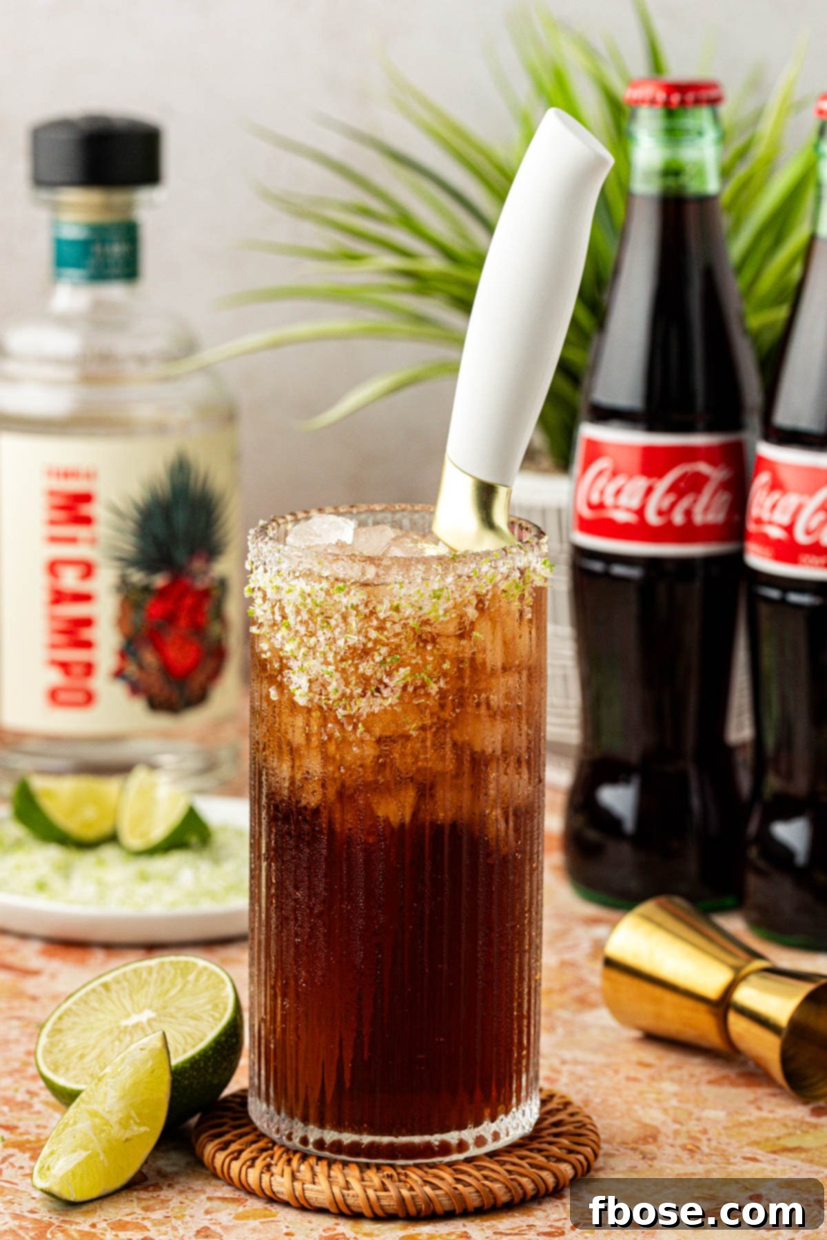 A glass with a Batanga cocktail in it with a knife in it.