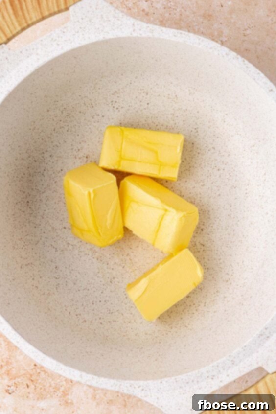 Butter sticks in a saucepan ready to melt.