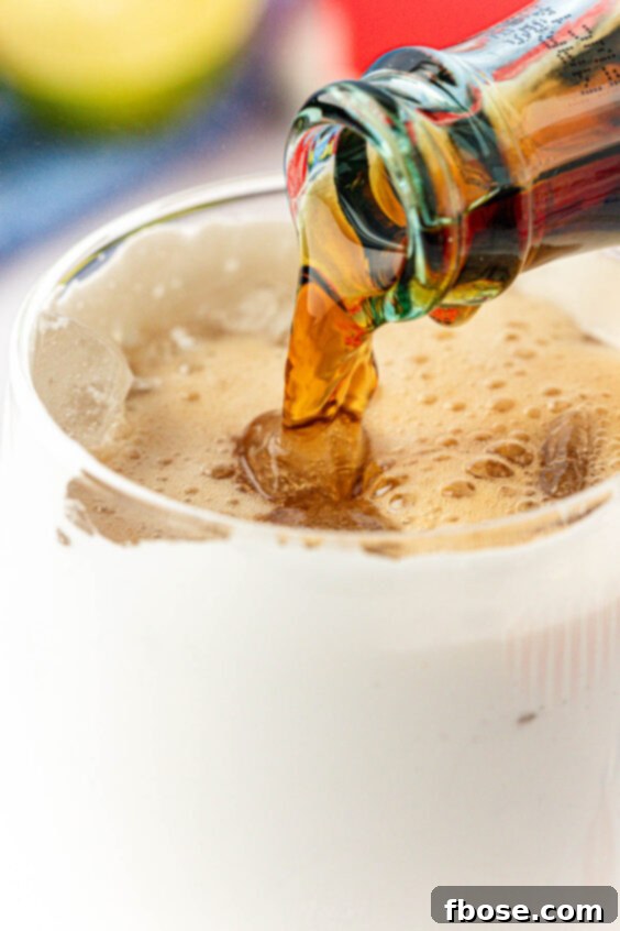 Coke being poured into a glass with fluff.