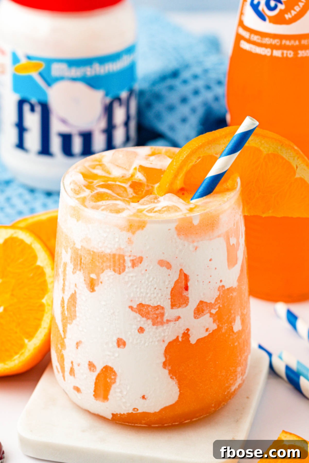 Close up of a Orange Fluffy Soda on a white coaster.