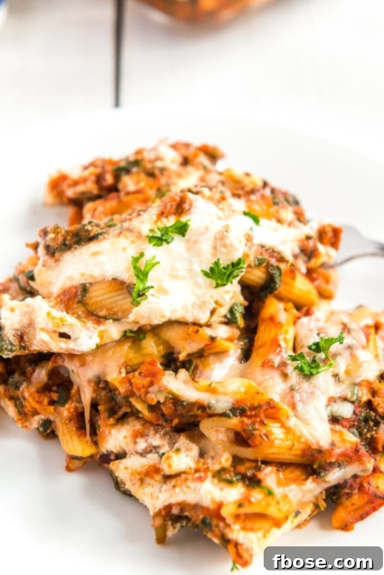 A serving of Turkey Florentine pasta bake on a white plate, showcasing its rich sauce, pasta, and cheese.
