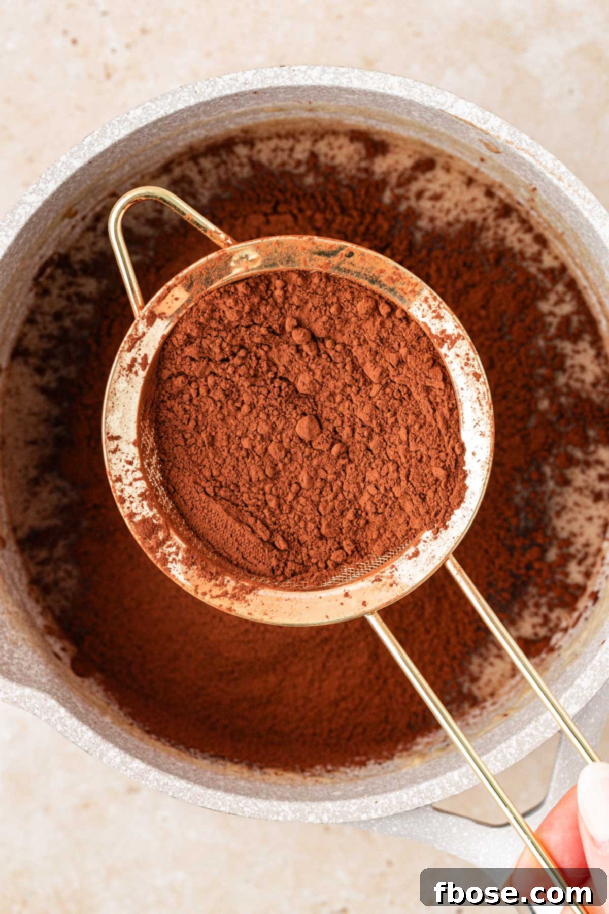 Rich Hot Fudge Sauce 5 Cocoa powder being sifted into a pot to make hot fudge.