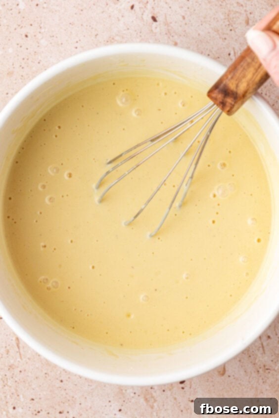 Muffin batter being whisked in a bowl.