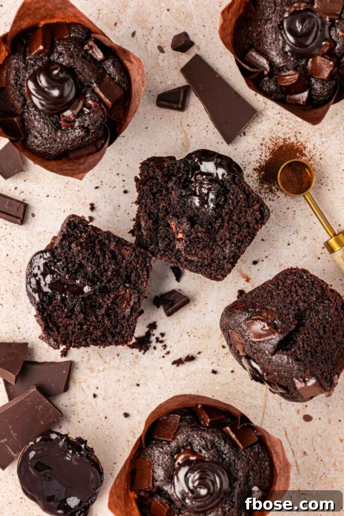 Overhead photo of several perfectly baked Olympic Chocolate Muffins arranged artfully on a table, ready for serving.