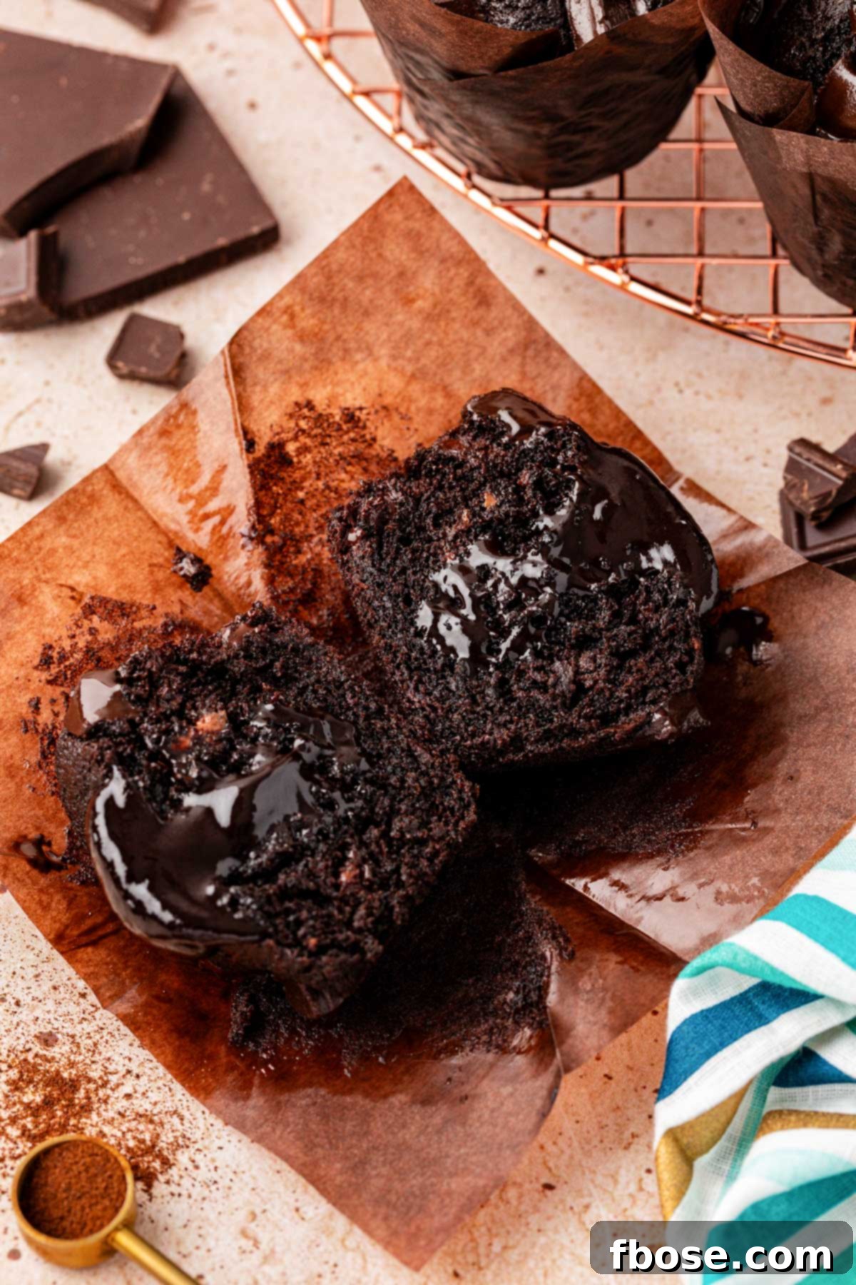 Close up of an Olympic chocolate muffin that has been cut in half, showcasing its inviting texture and luscious hot fudge center.