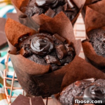 Olympic Chocolate Muffin on a wire rack, perfectly baked with a domed top, ready for its hot fudge filling.
