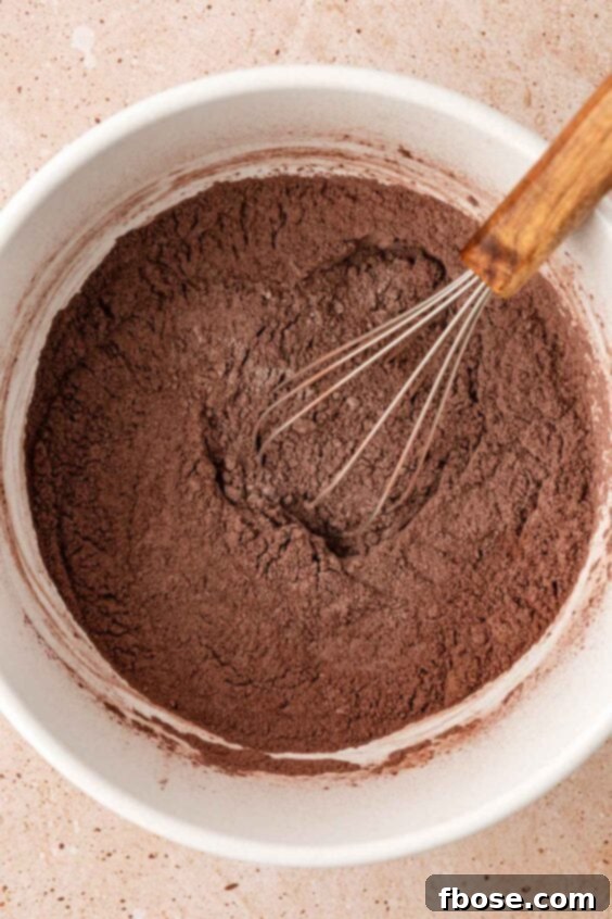 Dry ingredients for chocolate muffins being whisked in a bowl.