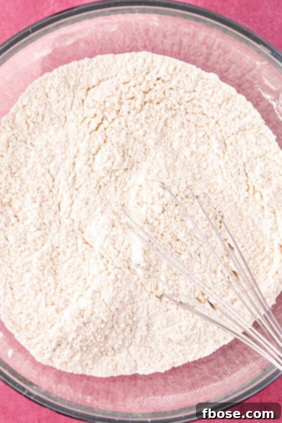 A bowl of dry ingredients being whisked to make cookies.