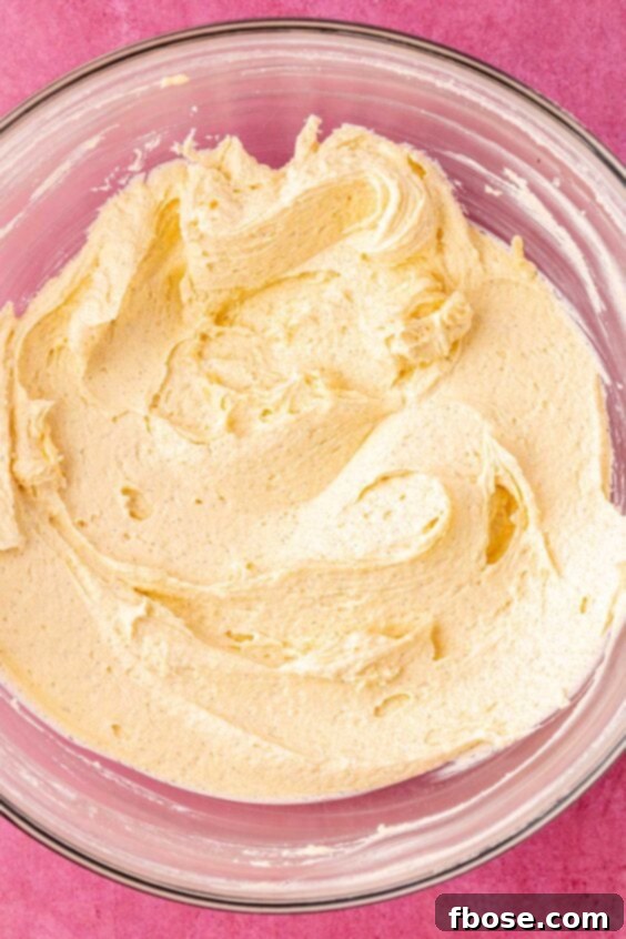 Butter and sugar creamed together in a glass bowl.