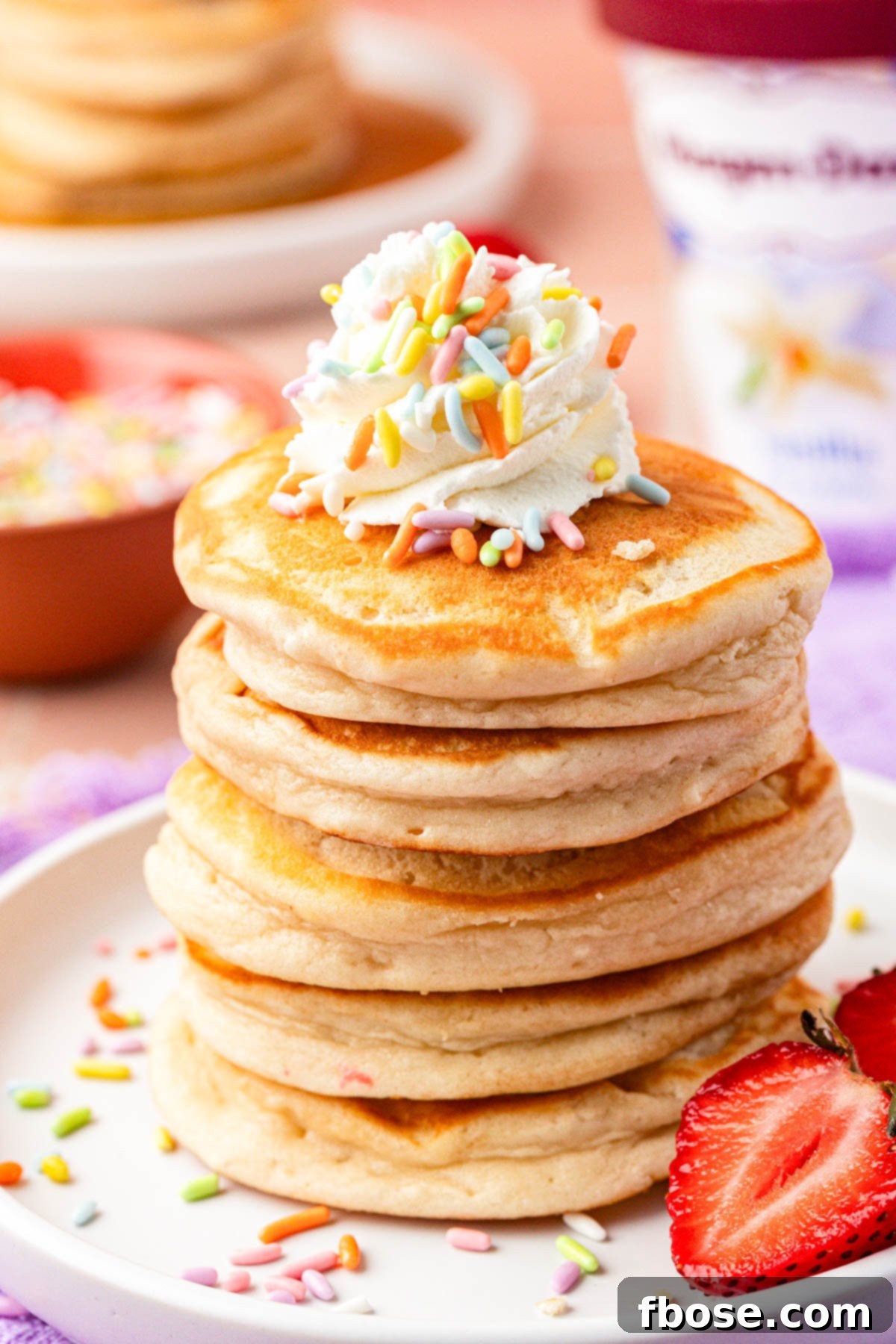 Close up of a stack of golden brown ice cream pancakes on a white plate, ready to be served.