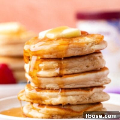 A stack of golden ice cream pancakes on a plate, glistening with syrup, ready to be enjoyed.