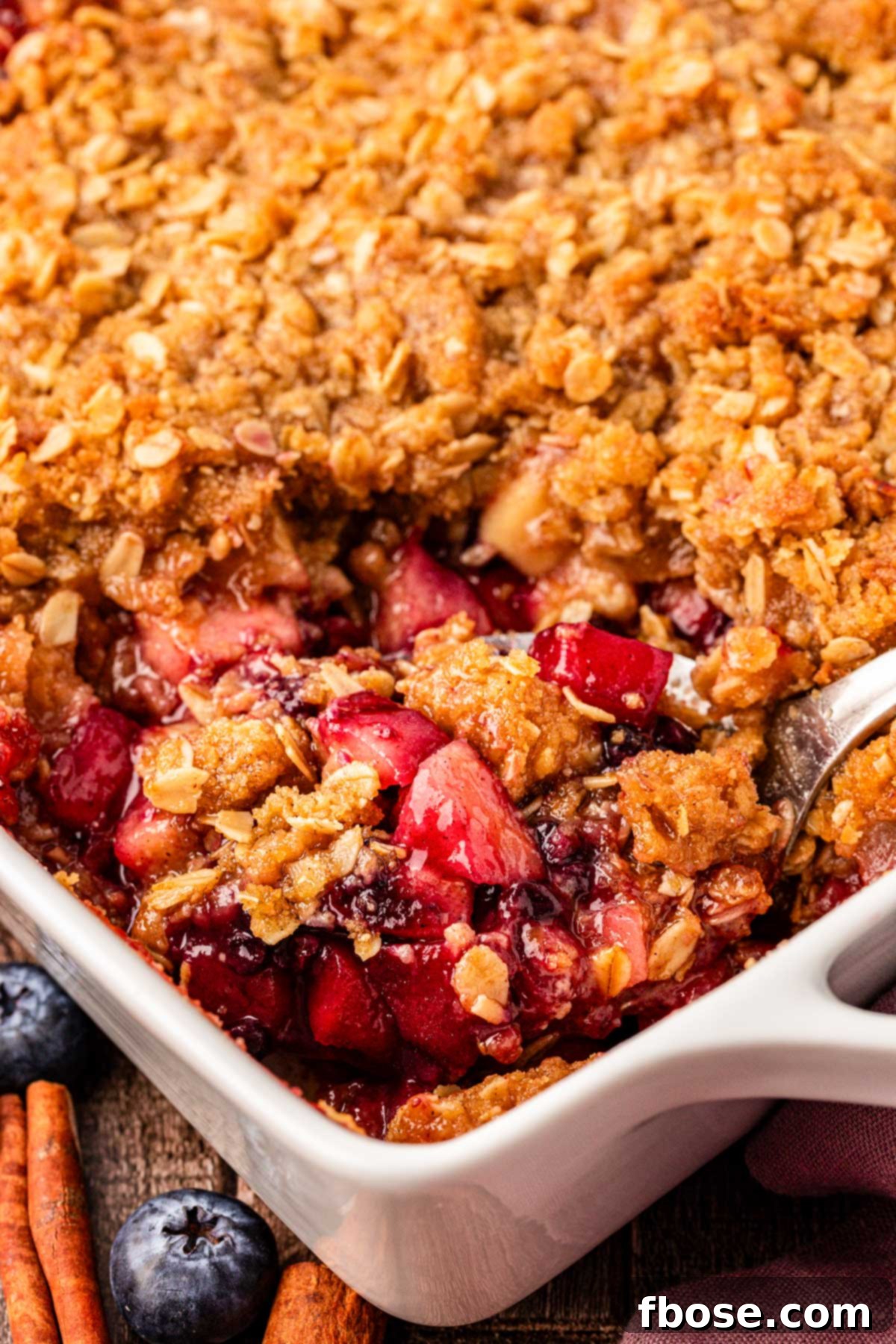 Warm Blueberry Apple Crisp 3 A spoon scooping blueberry apple crisp from a pan.