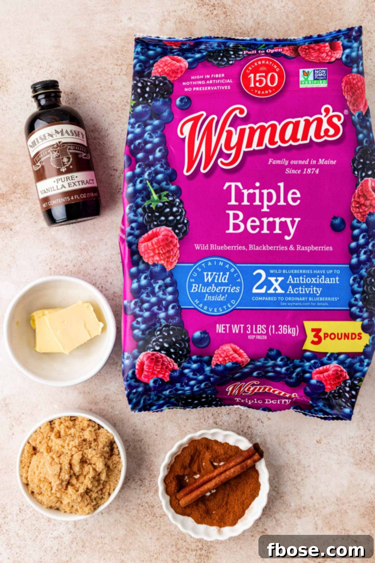 An overhead shot showcasing the simple, fresh ingredients needed to make homemade mixed berry compote, arranged on a rustic table.
