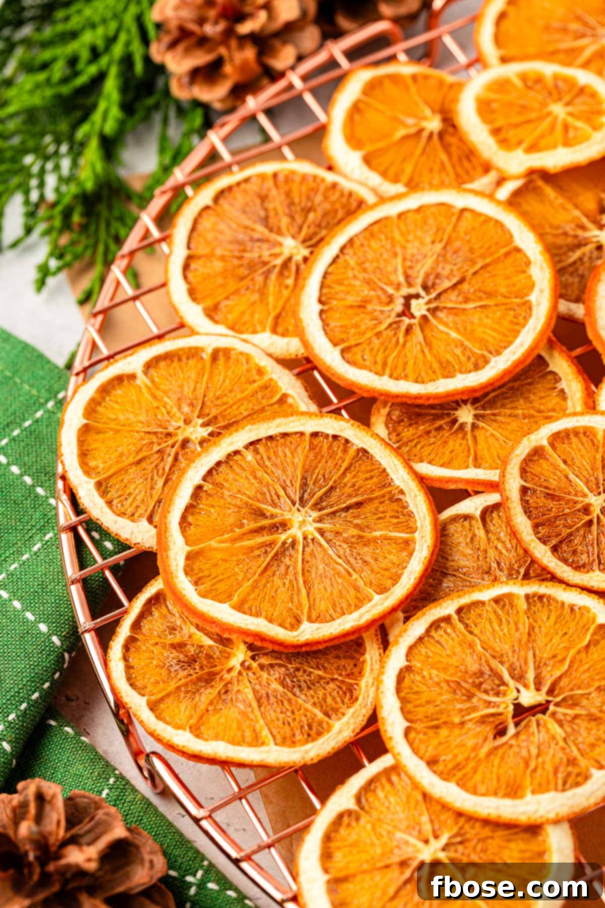 Oven-Dried Orange Slices 2 Beautifully arranged dried orange slices on a wire rack, ready for holiday crafting and decoration.
