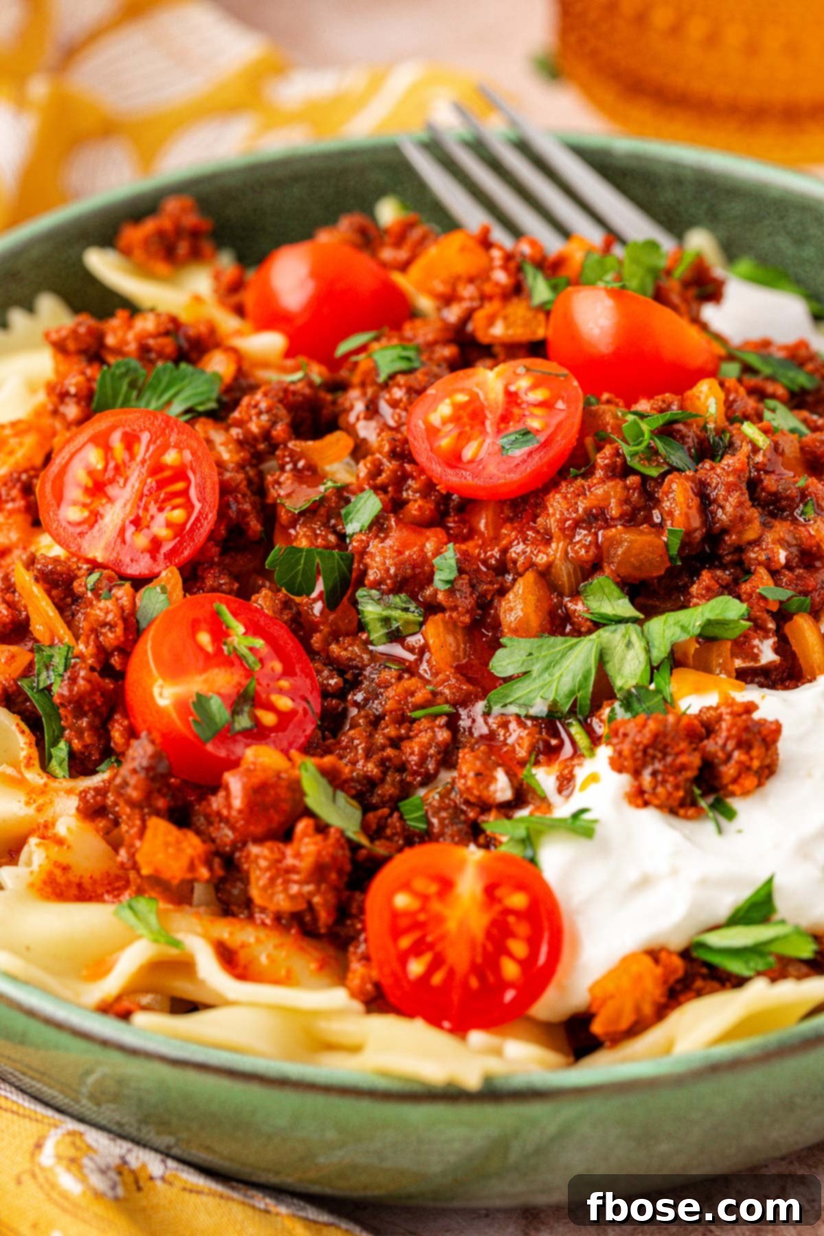 Close up of a bowl of Anna Paul's viral turkish pasta recipe, showcasing the rich layers of beef, pasta, and sauces.