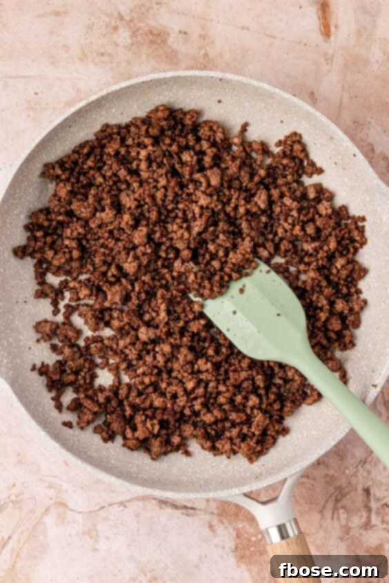 Ground beef being browned in a skillet.