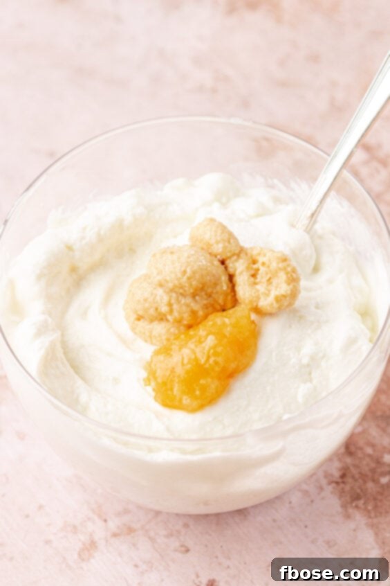 Garlic and lemon paste being added to a bowl of greek yogurt.