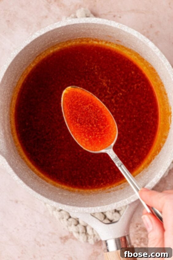 Paprika butter in a spoon over a pot.